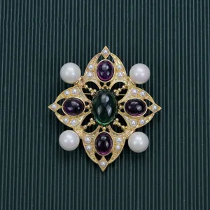 Macro detail of Baroque style vintage brooch with green and purple cabochon stones