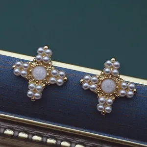 Detailansicht der goldfarbenen Vintage-Broschen in Kreuzform mit eleganten Perlen