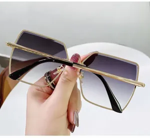 Nahaufnahme einer quadratischen Oversize-Sonnenbrille mit goldfarbenem Metallrahmen