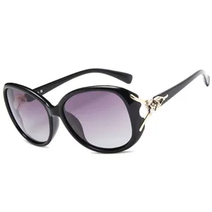 Elegante oversized zonnebril voor dames met paarse verloopglazen en goudkleurige vosdetails.