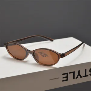 Vue détaillée de lunettes de soleil ovales tendance avec monture marron transparente.