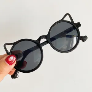 Cute black cat-ear sunglasses for kids, stylish and protective eyewear detail view.