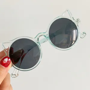 Detailed view of cute children's cat-ear sunglasses featuring transparent mint frames.