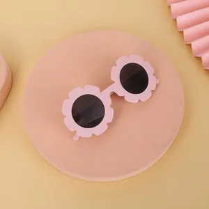 Gafas de sol de girasol rosa para niños con protección UV sobre un fondo estético.