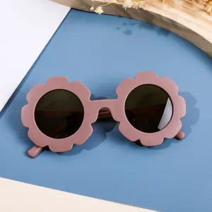 Gafas de sol infantiles con forma de flor rosa empolvado y cristales oscuros