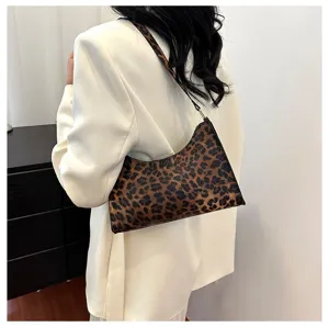 Detailed view of a trendy leopard print underarm bag worn by a model in a white blazer
