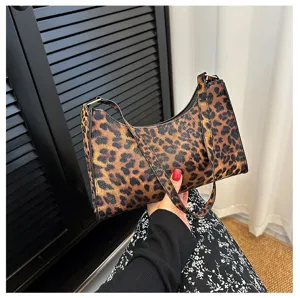 Elegant women's underarm bag featuring a classic leopard print pattern held by hand