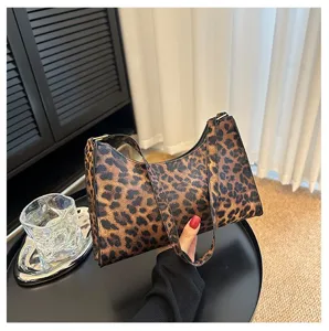 Detailed view of a stylish leopard print underarm shoulder bag being held by hand