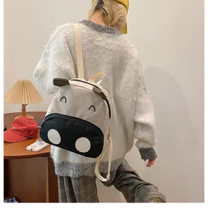Detailaufnahme eines süßen Kuh-Kinderrucksacks, der von einem Model getragen wird