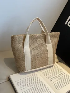 Detalle de primer plano de bolso de paja tejida con asas de tela crema resistentes