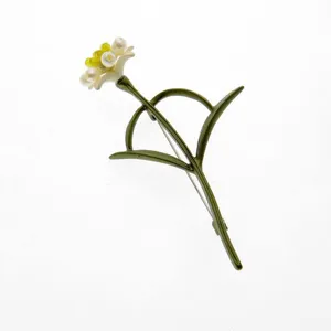Detailed view of an elegant vintage green enameled carnation brooch with pearl accents