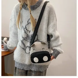 Süße Cartoon Kuh Umhängetasche für Kinder, getragen über einem kuscheligen Pullover