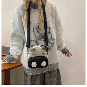 Niedliche Cartoon Kuh Umhängetasche an einem Model in einem gemütlichen Oversize-Pullover