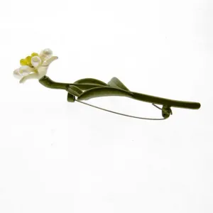 Detail view of green enamel carnation brooch with pearls and pin fastener.