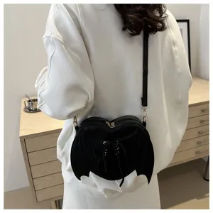 Achteraanzicht van een model met een unieke zwarte hartvormige crossbodytas met vleugels