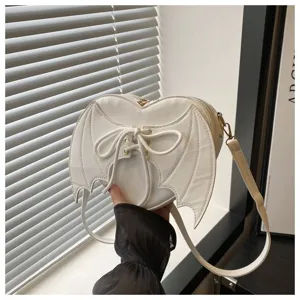 Detail van de witte hartvormige crossbodytas met uniek duivelsvleugelontwerp