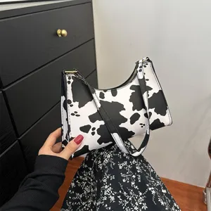 Vintage cow print underarm bag for women, chic black and white shoulder handbag detail