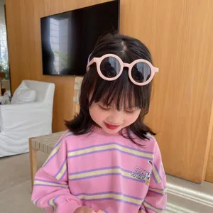 Gafas de sol infantiles redondas mate en color rosa usadas por una niña
