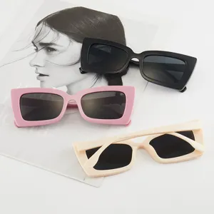 Modische quadratische Retro-Sonnenbrille in Schwarz, Rosa und Creme auf Magazin.