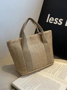 Vista detallada de un bolso de paja rústico con asas de lona beige y textura tejida