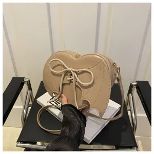 Detail van de hartvormige crossbodytas met unieke vleermuisvleugels en veters