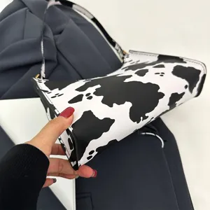 Close-up detail of stylish black and white cow print underarm bag for fashion women