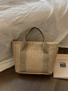 Vista detallada de un bolso shopper de paja para el verano con resistentes asas de lona para playa