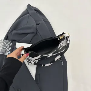 Close-up detail of a cow print baguette bag interior showing black lining and gold zipper