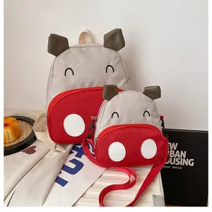 Set aus süßem Cartoon-Kuh-Kinderrucksack und passender roter Umhängetasche für Mädchen