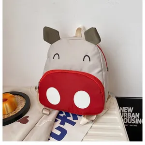 Nahaufnahme eines süßen Zeichentrick-Kuh-Rucksacks mit einer roten Vordertasche.