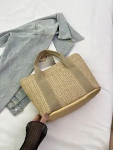 Primer plano de un bolso de paja trenzada con una base dorada metálica elegante