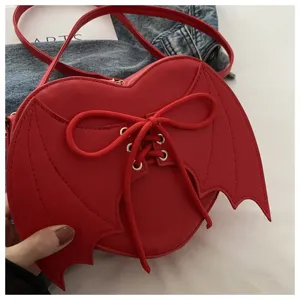 Gedetailleerd overzicht van rode demon hartvormige crossbody tas met vleermuisvleugels