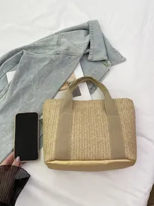 Detalle del bolso de paja de verano con base metálica sobre fondo vaquero