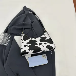 Trendy cow print underarm bag for women featuring a minimalist black and white design