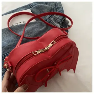 Rode hartvormige crossbody tas met vleugeldetails en gouden dubbele ritsen detail.