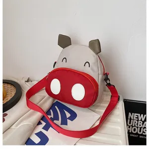 Detailansicht der niedlichen Comic-Kuh-Kinderschultertasche mit einem roten Tragegurt.