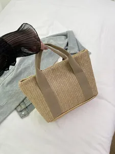 Primer plano de un bolso de paja tejido con patrón de espiga para las vacaciones de verano