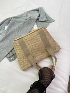 Detalle de un bolso de paja tejida natural con asas de tela suave para el verano