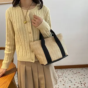 Bolso de paja trenzada con asas de tela negra, ideal para las vacaciones de verano