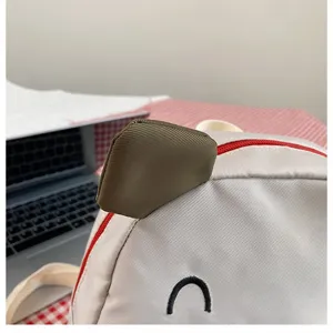 Nahaufnahme des niedlichen Kuh-Ohr-Details und des roten Reißverschlusses am Kinderrucksack.