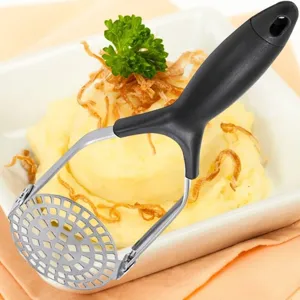 Close-up of a foldable stainless steel potato masher on a bowl of mashed potatoes