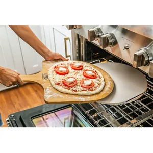Close-up van een bamboe pizzaschep die pizza op een baksteen in een keukenoven plaatst