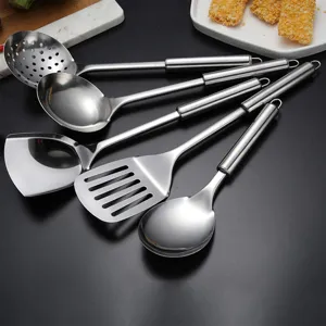Detalle de un juego de utensilios de cocina de acero inoxidable con espátula y cucharón