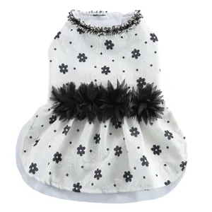 Vue détaillée de la robe pour chien blanc avec imprimé floral noir et fleurs à la taille.