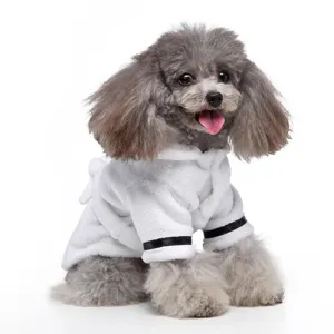 Close-up of a small poodle wearing a white hotel-style pet bathrobe with a hood