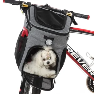 Dettaglio di un piccolo cane bianco seduto in una borsa grigia da trasporto per bicicletta