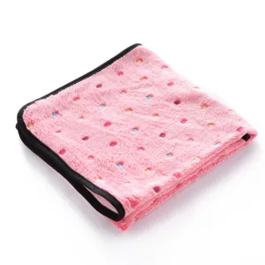 Close-up detail of the pink fleece pet blanket with colorful printed dots and black edge binding.
