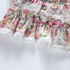 Vista detallada del vestido floral para mascotas con delicado borde de encaje blanco y anilla.