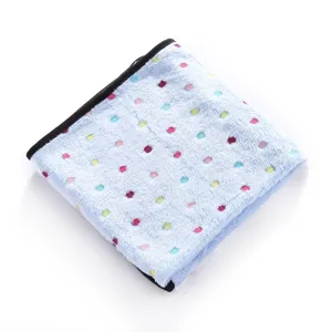 Detail shot of soft double-sided fleece pet blanket with colorful paw print pattern and black trim.