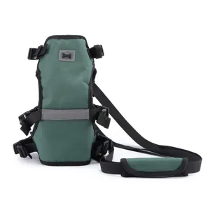Dettaglio dell'imbracatura per cani verde scuro con striscia riflettente e resistenti cinghie nere.